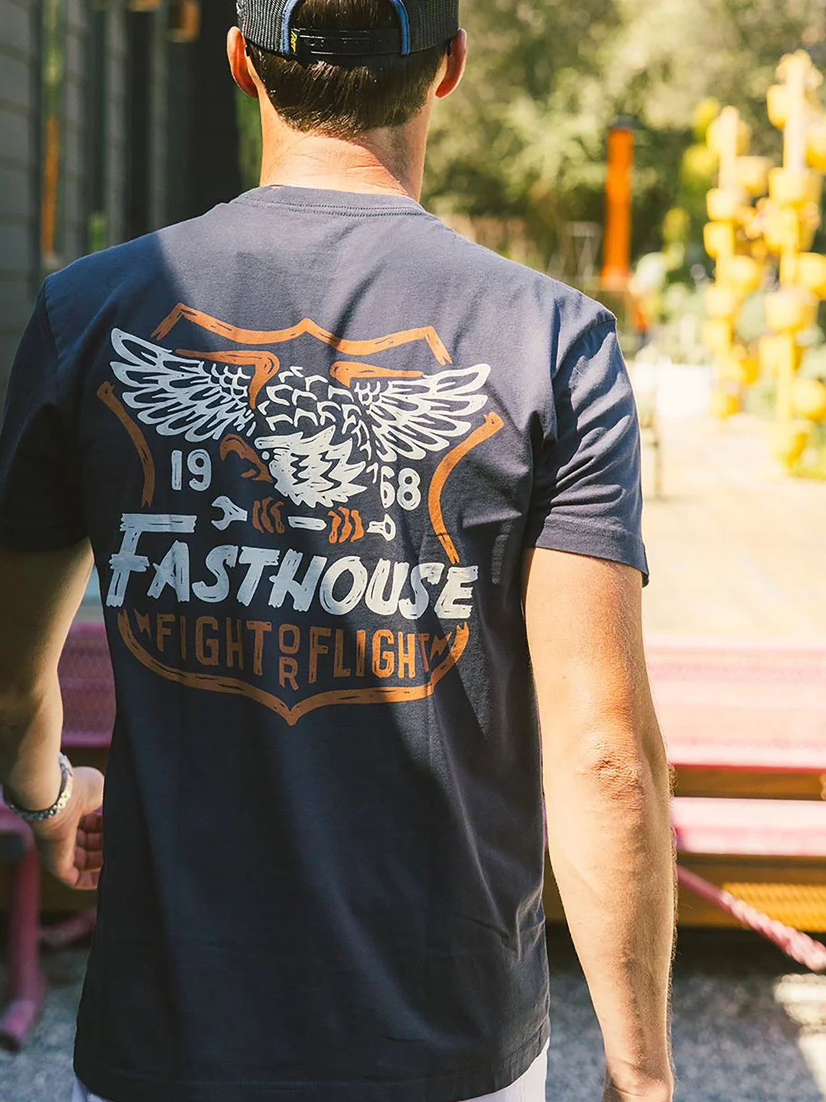 Fasthouse Men's Talon Graphic T-shirt in Graphite Black, lifestyle view showing the back graphic