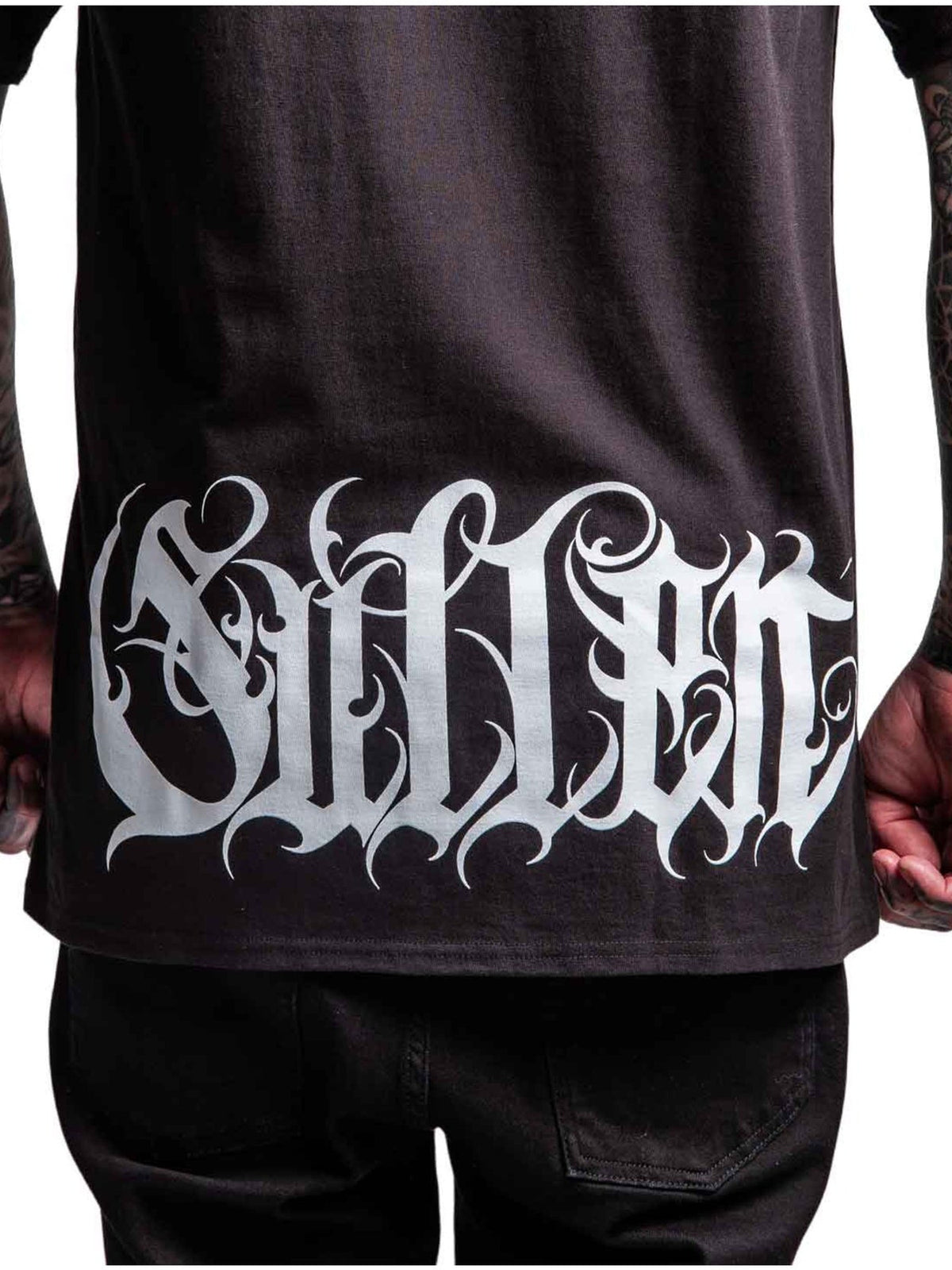 Close-up of the ornate white Sullen script printed across the Taste T-shirt back hem
