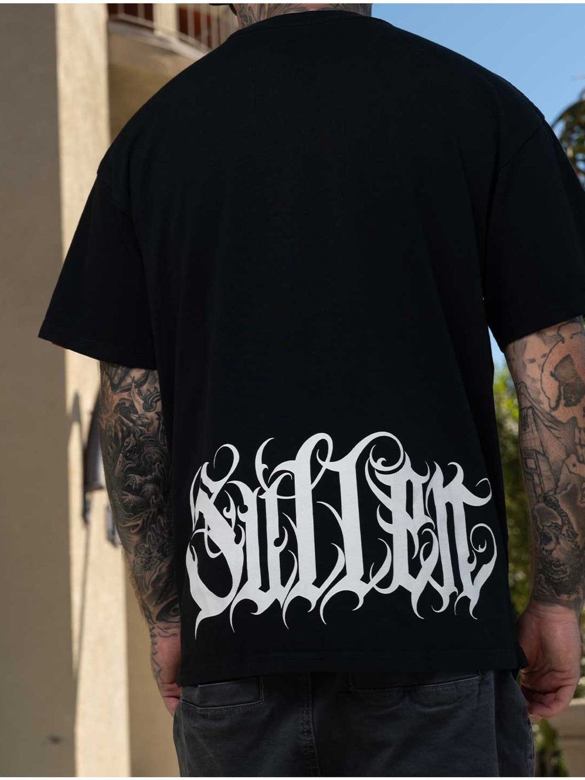 Styled back view of the Sullen Taste 1 Ton Caviar T-shirt with large white Sullen script