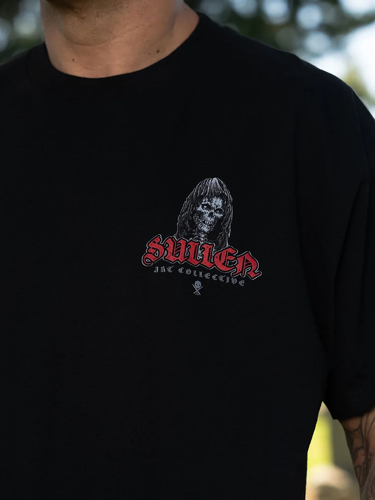 Styled front view of the Sullen Divine Reaper T-shirt with hooded skull chest print