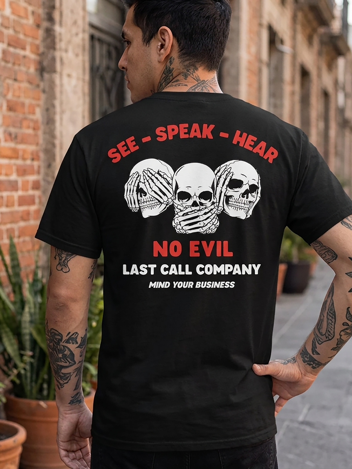 Last Call Co No Evil Badge Graphic T-Shirt Black lifestyle back view featuring horned devil face and Hear No Evil See No Evil Speak No Evil back graphic