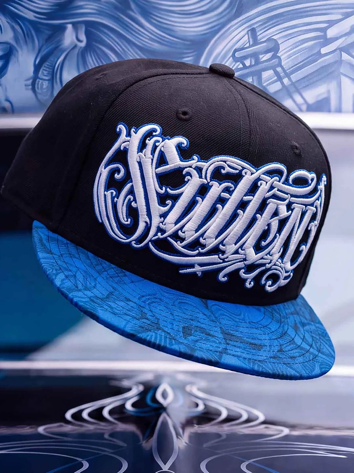 Sullen Sad Boy black and blue snapback in a tattoo-art lifestyle display