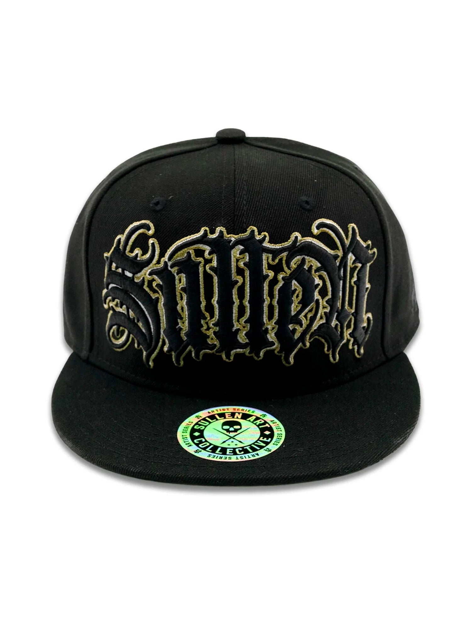 A black flat-brim snapback cap featuring a large, stylized gothic-style embroidered logo on the front in black and gold, with a green and white circular sticker on the brim.