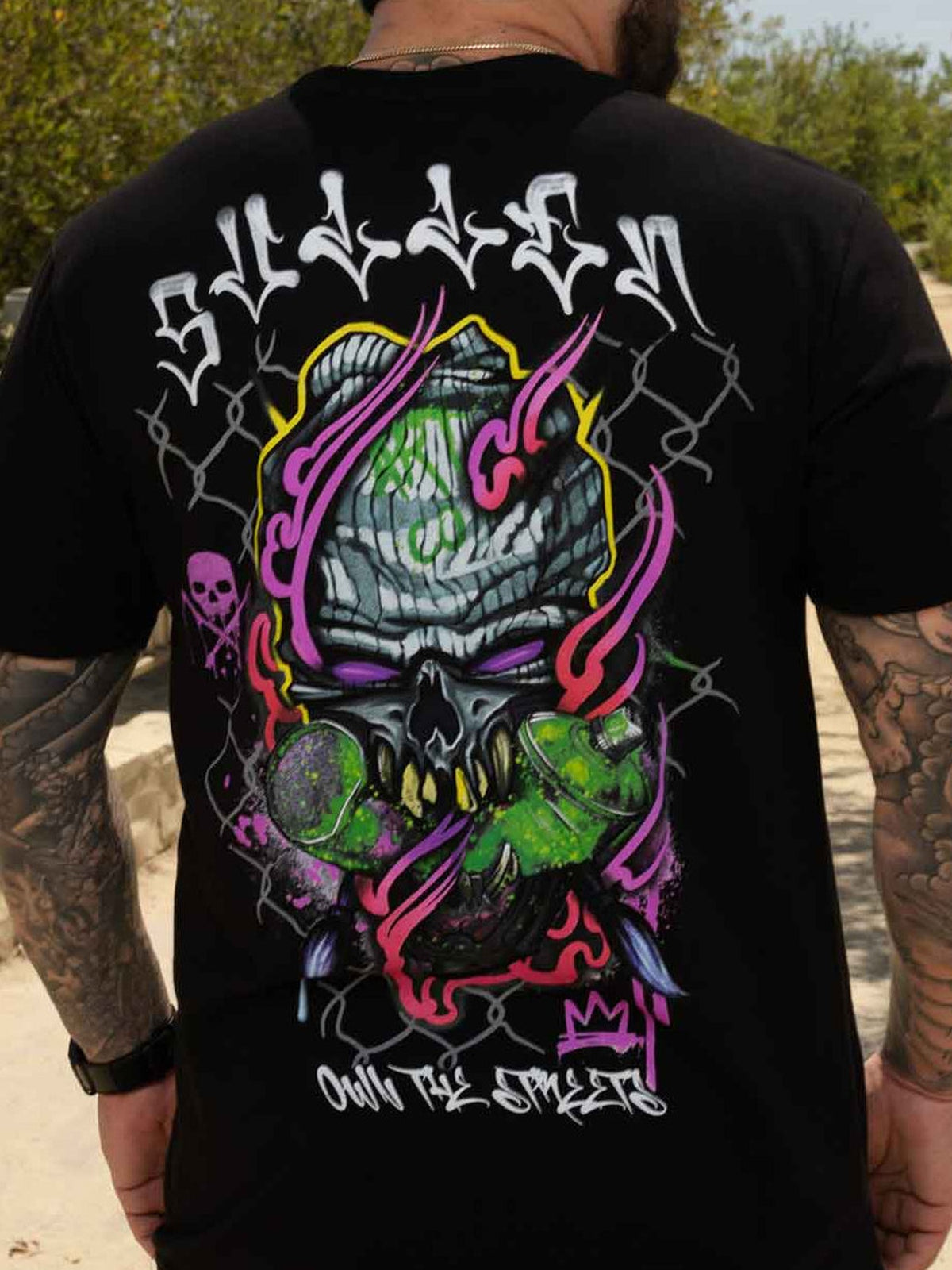 Outdoor rear view of the Jet Black Chemical Swirl tee showing the neon skull artwork