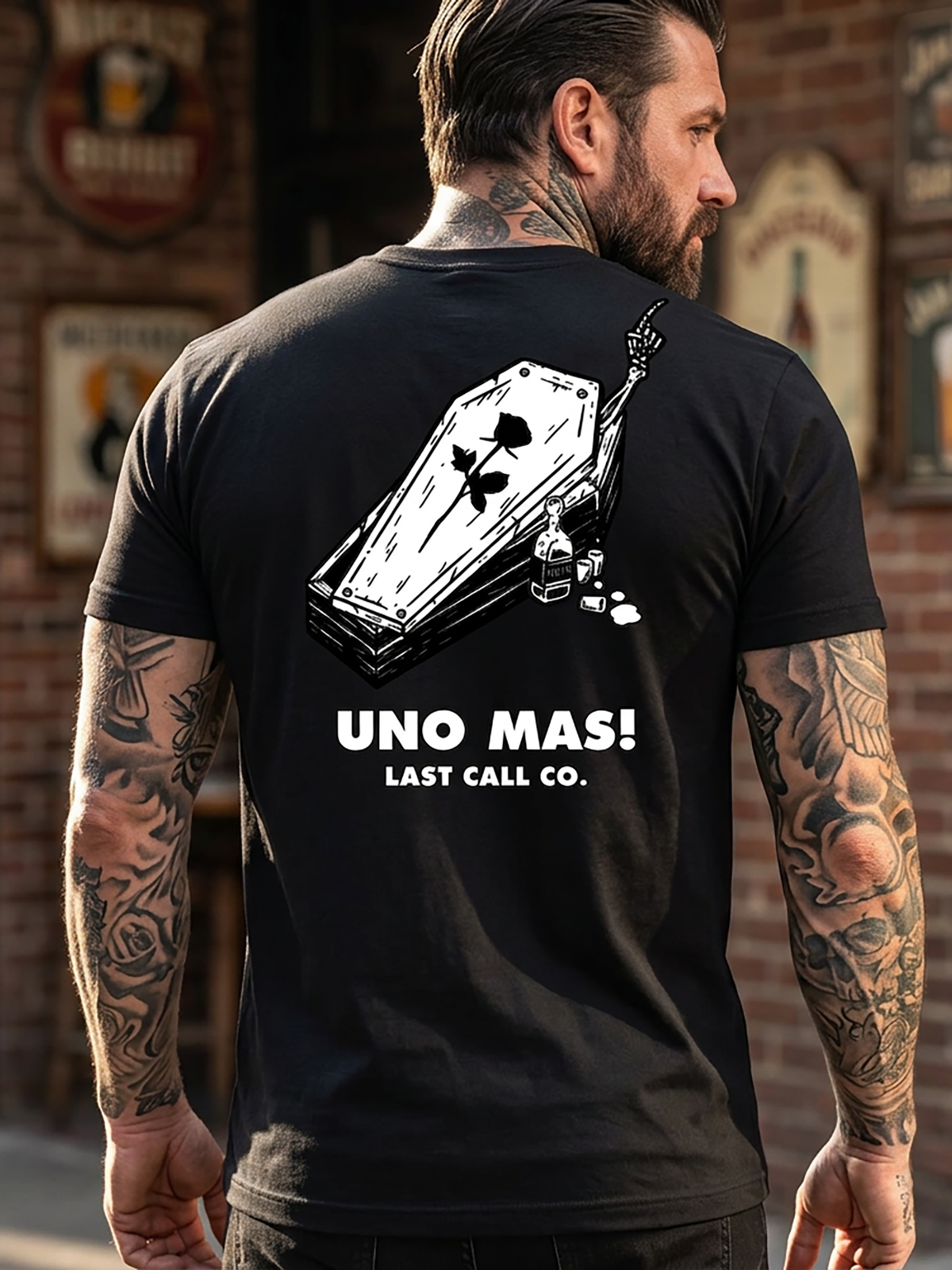 Last Call Co Uno Mas Graphic T-Shirt Black lifestyle back view featuring raised drink glasses, a skeletal hand, and Uno Mas One More Always De Nada artwork